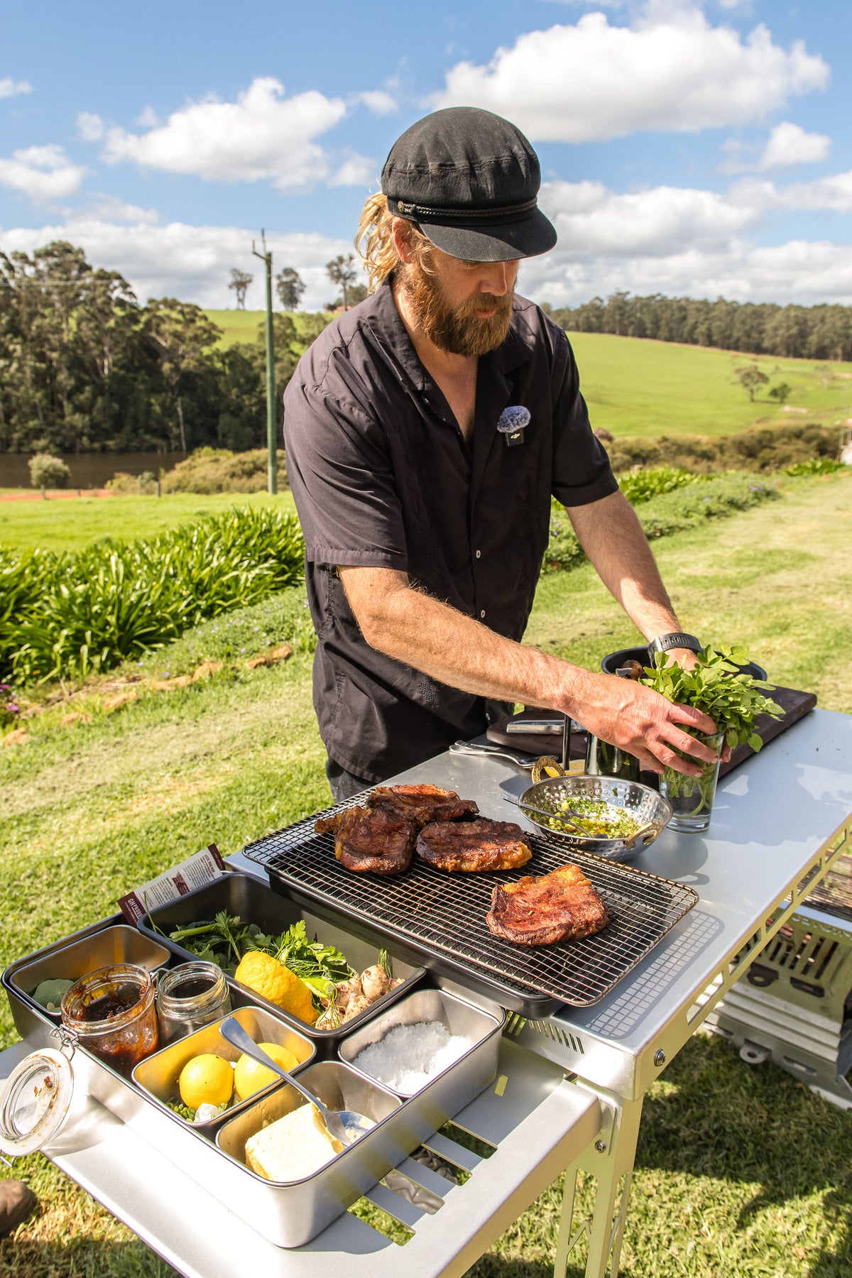 Chef Glen preparing the feast at an outdoor cooking station overlooking the farm