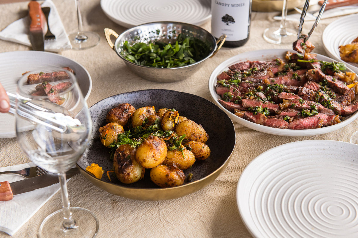 The long table set with beef, roast potatoes, greens and Canopy Wines