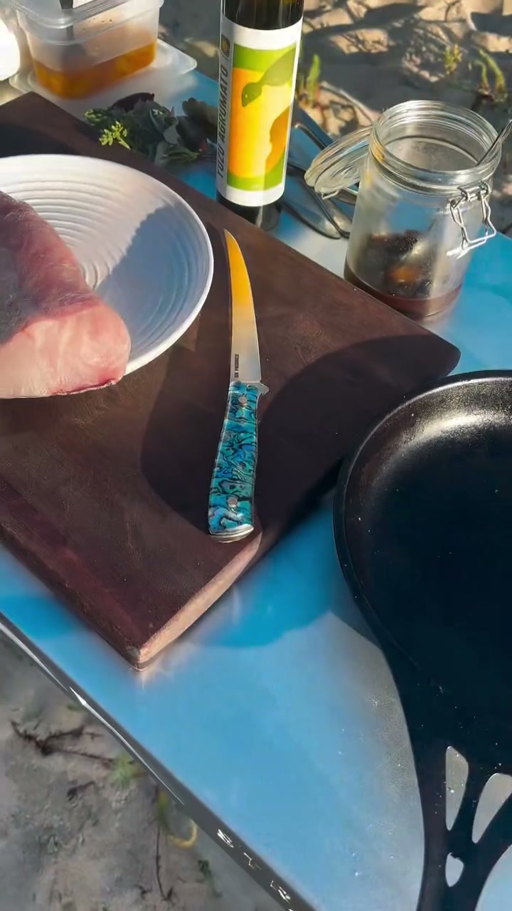 An Iron Gate knife on the board beside a fresh fillet