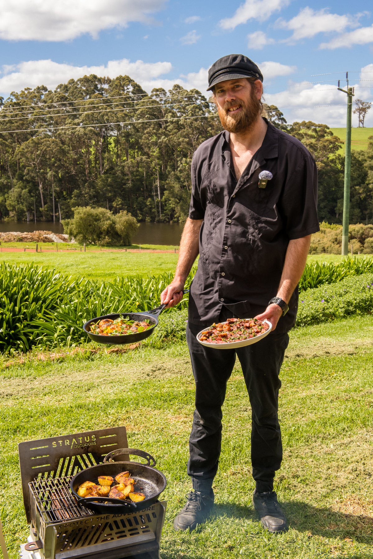 Chef Glen holding the finished dishes beside the outdoor kitchen