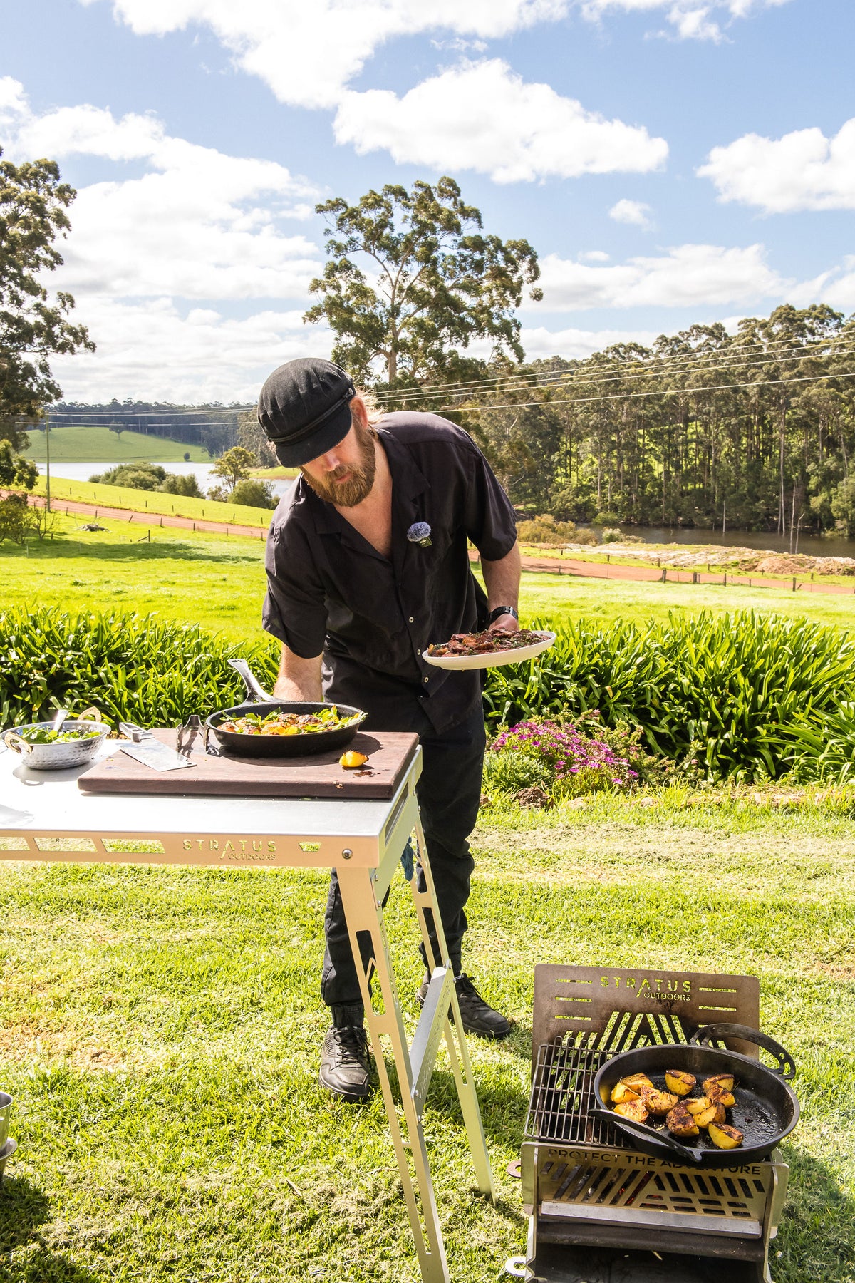 Chef Glen carrying the finished dish past the Stratus Outdoors fire pit